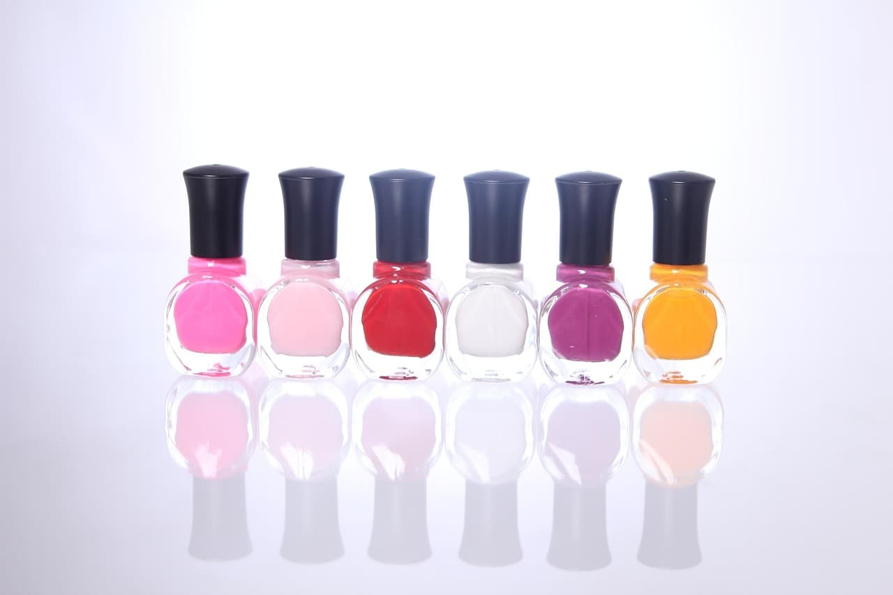 A row of gel polish bottles in pinks, reds and lilac