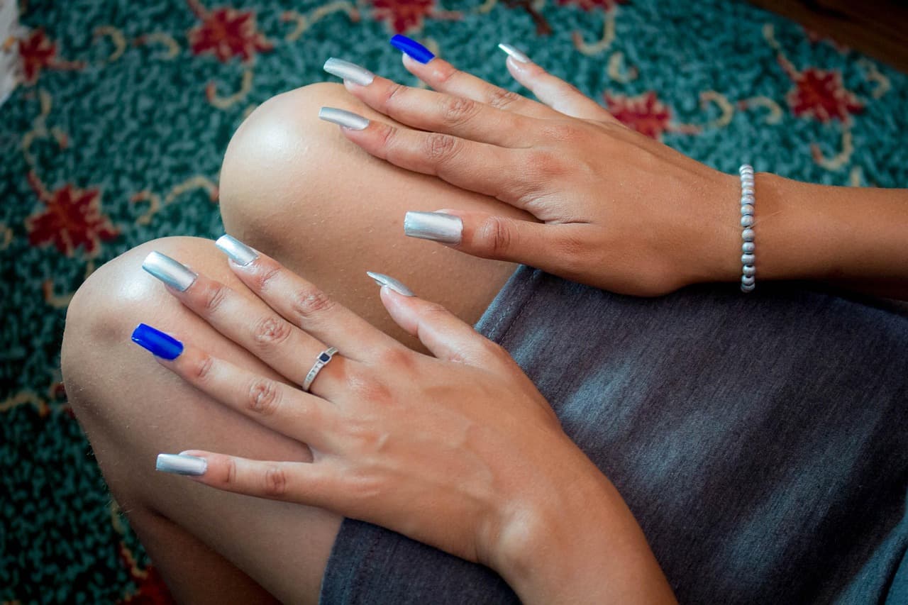 Long white acrylic nails with one blue accent nail